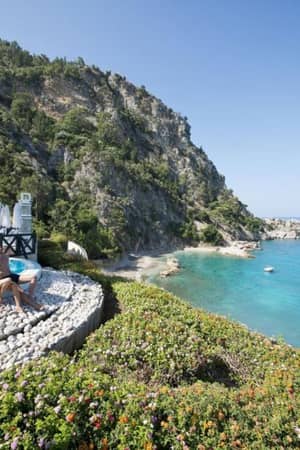 View from Liberty Lykia pool overlooking turquoise Mediterranean Sea and lush cliffs.