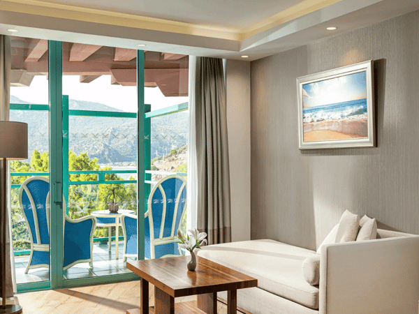 Liberty Sentido Deluxe hotel room with chaise longue and balcony overlooking the sea.