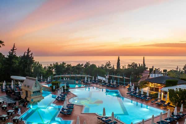 Aerial view of Liberty Sentido Lykia hotel with swimming pool and sunset over the sea.