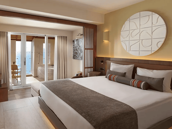 Luxurious hotel room at Liberty Village with a king-sized bed, balcony with sea view, and private jacuzzi.