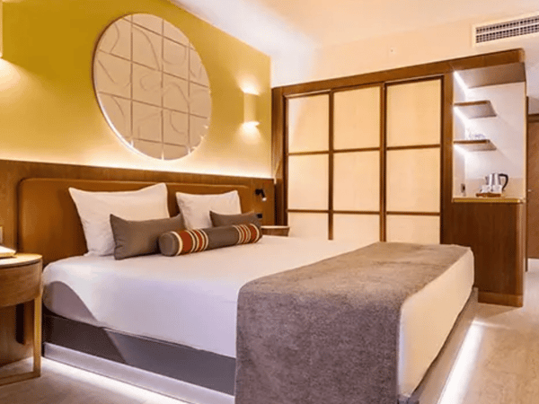 Liberty Village Deluxe Standard Sea View room with a king-size bed, modern decor, ambient lighting, and a coffee station.