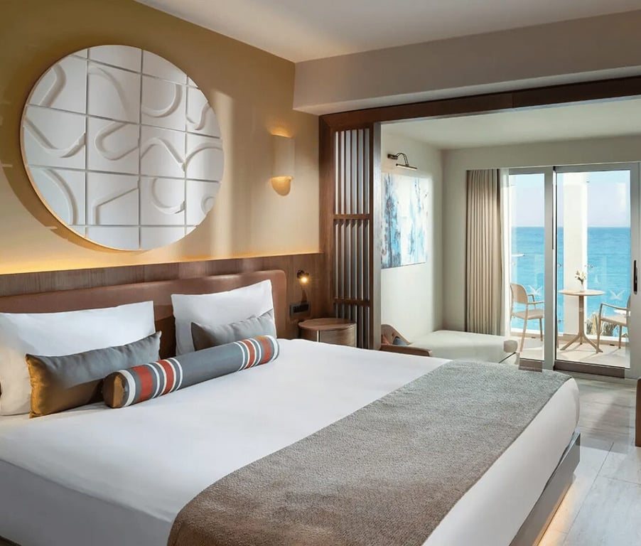 Luxury hotel room at Liberty Village with double bed, stylish decor, and a sea view balcony.