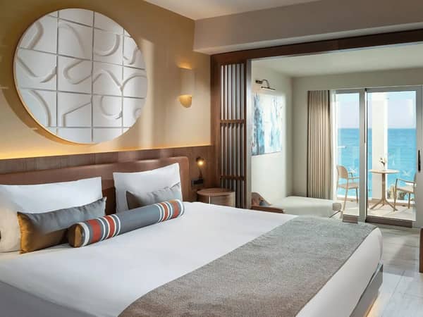 Luxury hotel room at Liberty Village with double bed, stylish decor, and a sea view balcony.