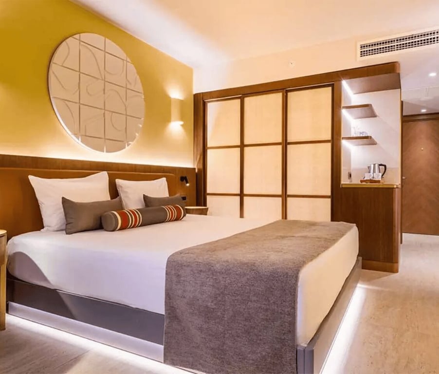 Liberty Village FTH Deluxe Standard room with a king-sized bed, elegant decor, warm lighting, and sea view.