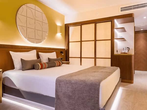 Liberty Village FTH Deluxe Standard room with a king-sized bed, elegant decor, warm lighting, and sea view.