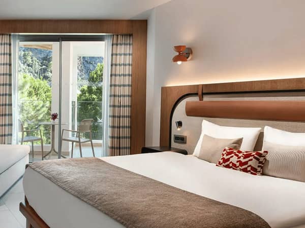 Liberty Village deluxe standard room with a double bed, modern decor, and a balcony offering a side sea view.