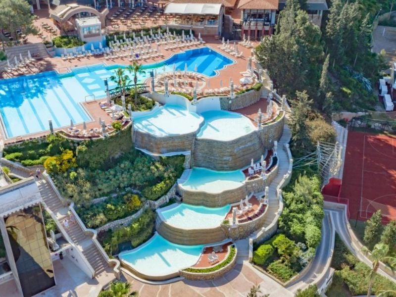 Aerial view of tiered infinity pools at Liberty Village, surrounded by greenery and leisure facilities.