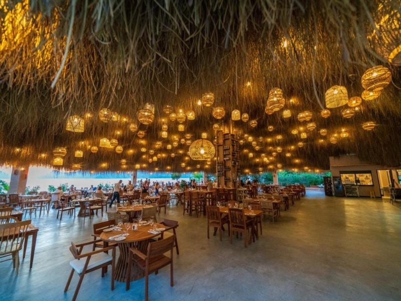 Liberty Village restaurant with rattan light fixtures hanging from the ceiling and wooden dining furniture creating a cosy, open-air ambiance.