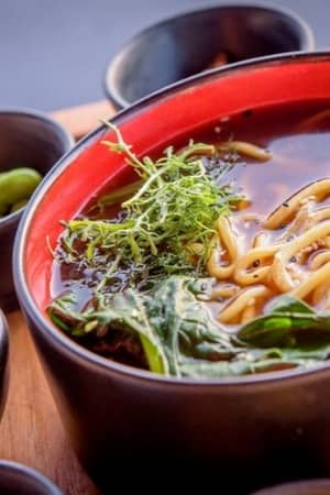 Asian noodle soup with broth, noodles, fresh greens, and edamame beans from Lyttos Mare.