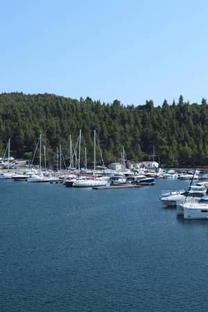 Yachts and boats docked at Meliton Gallery marina, surrounded by green hills and blue waters.