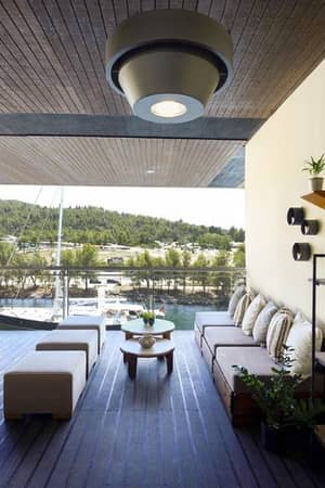 Outdoor deck at Meliton Gallery with lounge furniture, marina view, and green hills in the background.