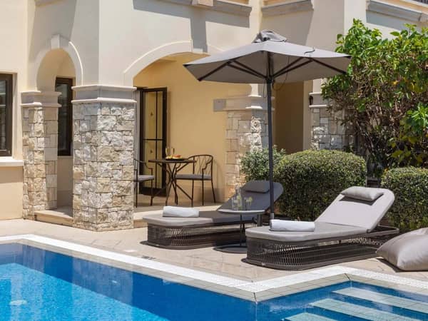 Luxurious one-bedroom suite with a private pool, featuring sun loungers, parasol, and limited sea view.