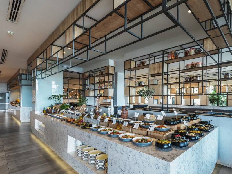 Buffet area at Paloma Family Holidays resort with an array of dishes and modern interior design.