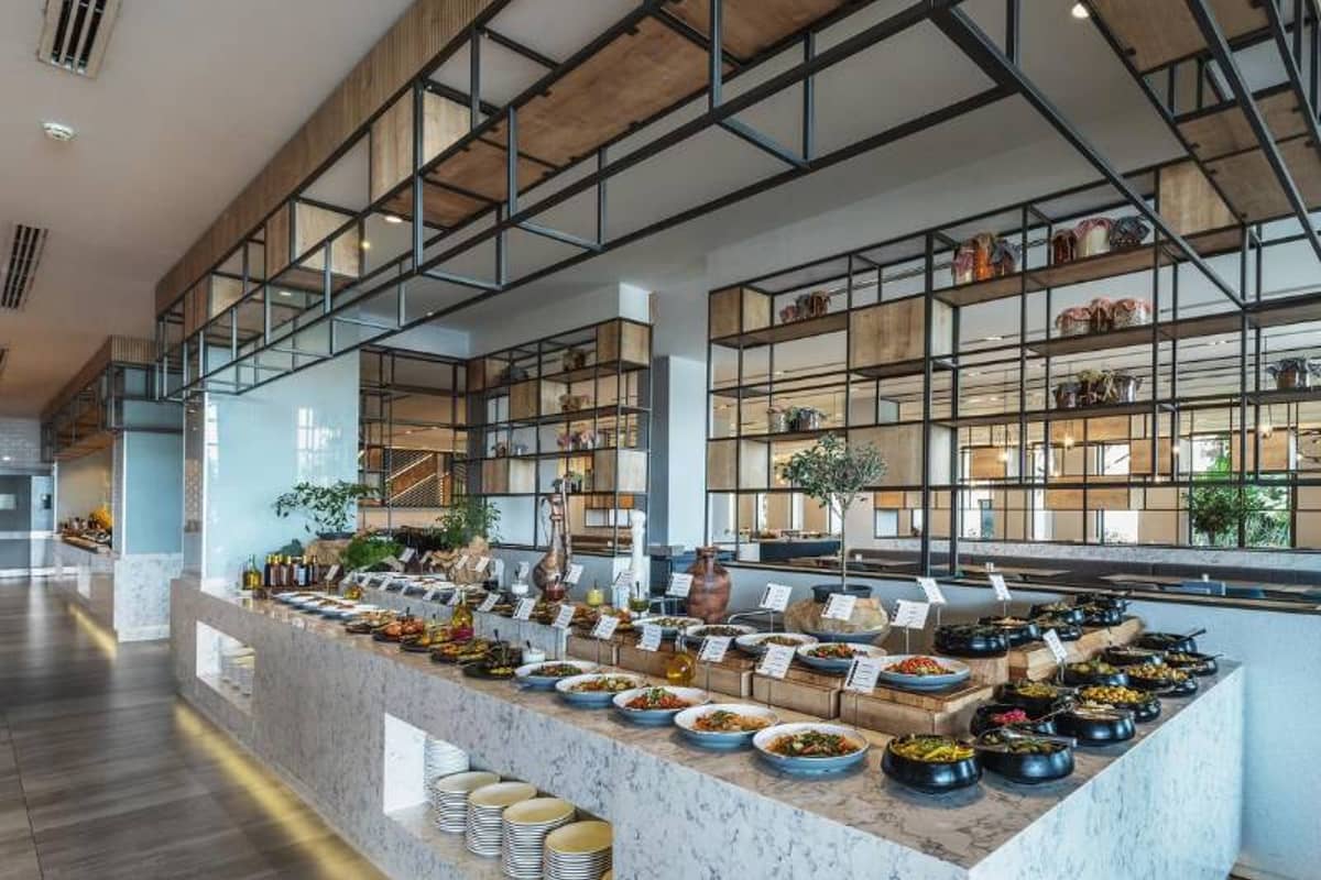 Buffet area at Paloma Family Holidays resort with an array of dishes and modern interior design.