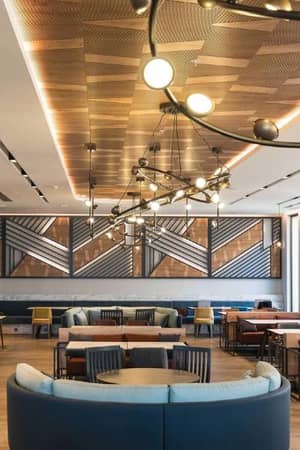Modern restaurant interior at Paloma Family Holidays, featuring stylish lighting, geometric wall art, and comfortable seating.