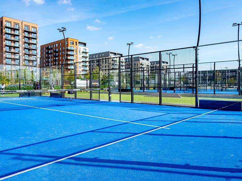 Outdoor padel court at Parkside with modern buildings in the background on a sunny day.