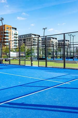 Outdoor padel court at Parkside with modern buildings in the background on a sunny day.