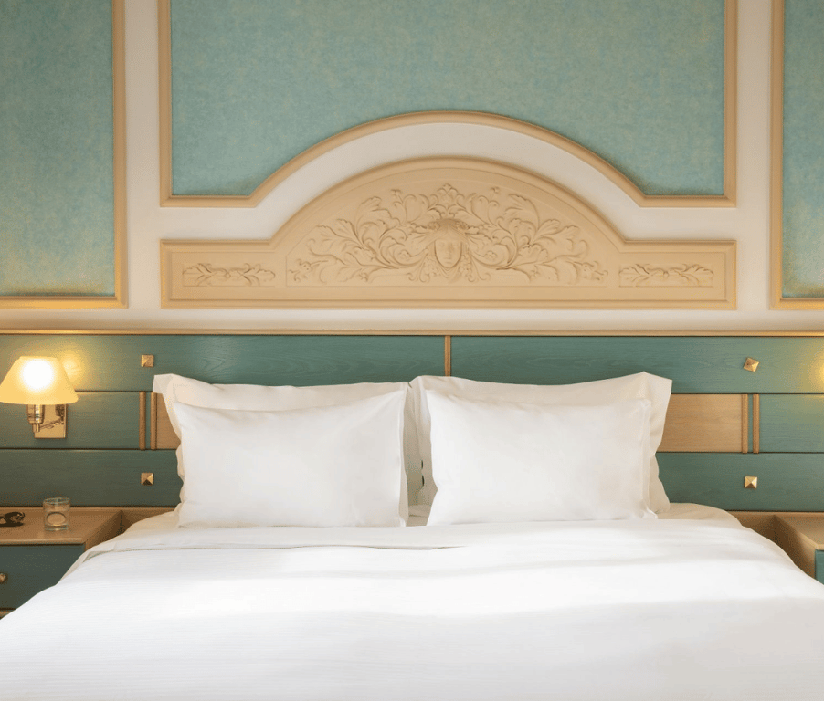 Royal Mare Double-Twin Bungalow with two twin beds, elegant teal and beige interior, and views of a manicured garden.