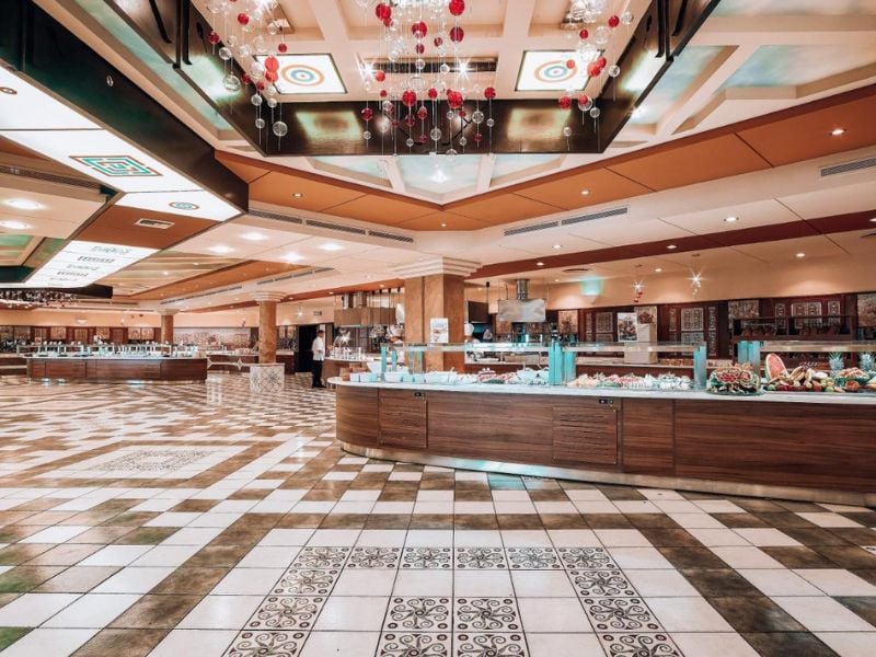 Expansive buffet area at Royal Mare Gallery with modern wooden counters, a tiled floor, and decorative ceiling lights.