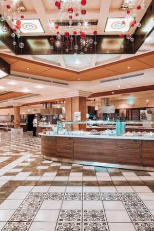Expansive buffet area at Royal Mare Gallery with modern wooden counters, a tiled floor, and decorative ceiling lights.
