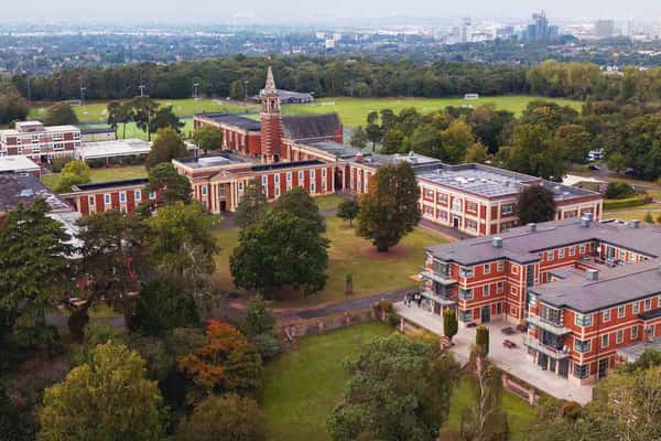 Aerial view of the Royal Russell School campus, featuring brick buildings and abundant greenery on a sunny day.