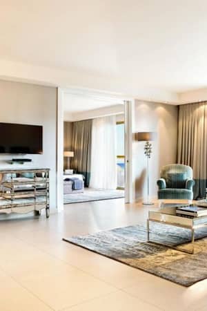 Luxurious hotel room at Sani Beach with modern furniture and large windows showing an ocean view.