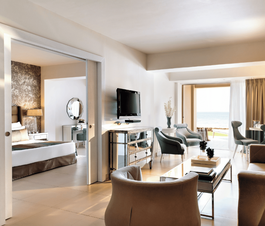Interior of a one-bedroom family suite at Sani Beach, showcasing a living area with elegant furniture and a private terrace with sea views.
