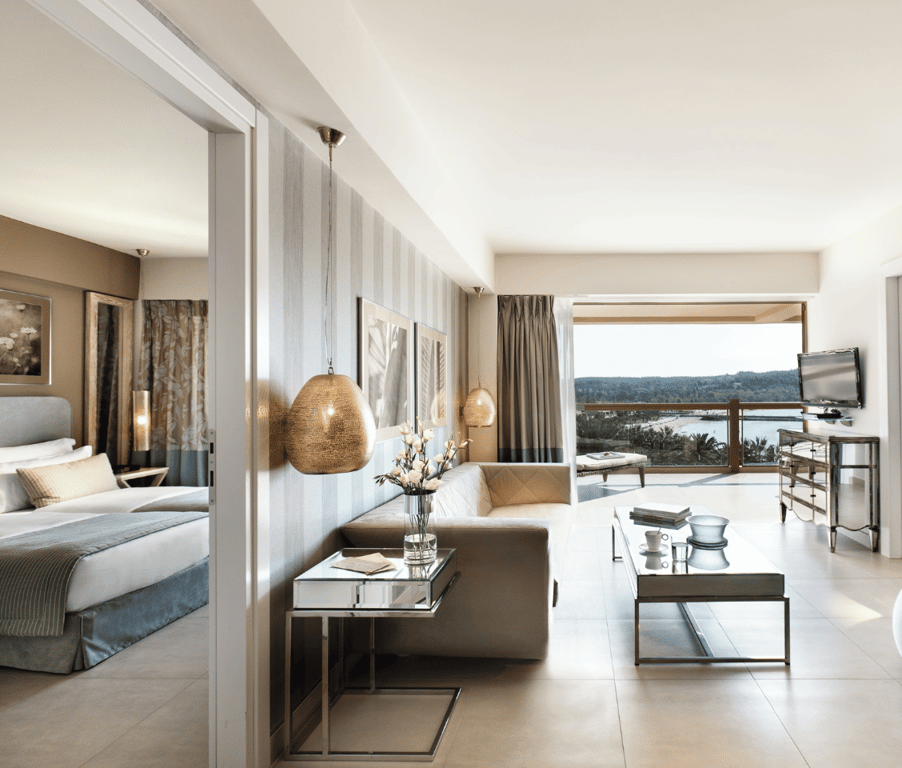 Two-bedroom family suite at Sani Beach with sea view featuring modern decor, spacious living area, and large windows with ocean scenery.