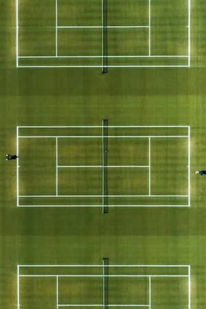 Aerial view of tennis courts at The Lensbury, showing two green courts and a clay court with clear white boundary lines.