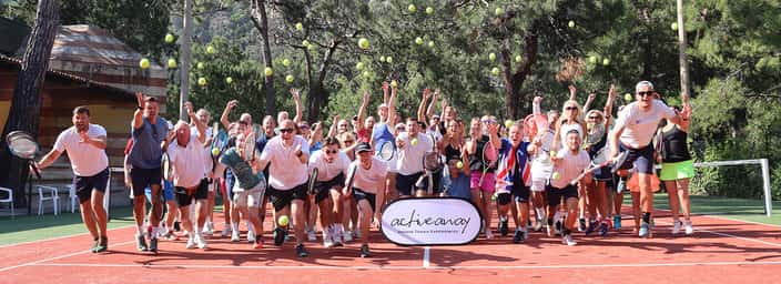 Group of people jumping on a tennis court, each with a tennis racket, and a banner with 'achieve more' in front surrounded by floating tennis balls.