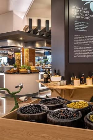 Dining area in Valamar resort with gourmet olive display and vintage bicycle, highlighting Istria as the best olive oil region.