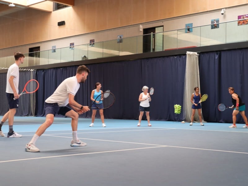 Tennis coaching session at Virgin Active Chiswick with players on an indoor court receiving training.