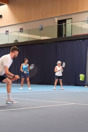 Tennis coaching session at Virgin Active Chiswick with players on an indoor court receiving training.