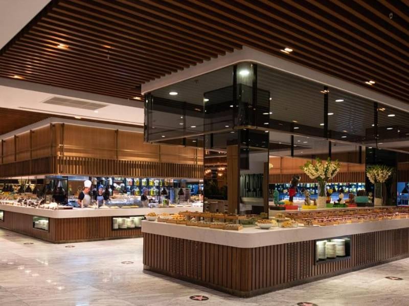 Modern dining area at Vogue Gallery with a buffet layout, featuring wooden panelling and elegant lighting.