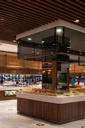 Modern dining area at Vogue Gallery with a buffet layout, featuring wooden panelling and elegant lighting.