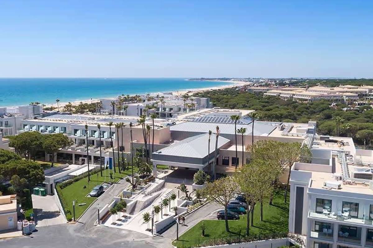 Aerial view of Barosa Park Hotel with its modern architecture and surrounding greenery, set against stunning coastal sea views.