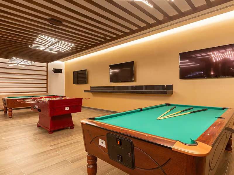 Recreation room at Barosa Park Gallery with a pool table, foosball table, and flat-screen televisions.