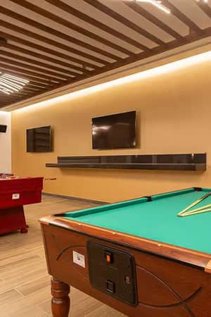 Recreation room at Barosa Park Gallery with a pool table, foosball table, and flat-screen televisions.