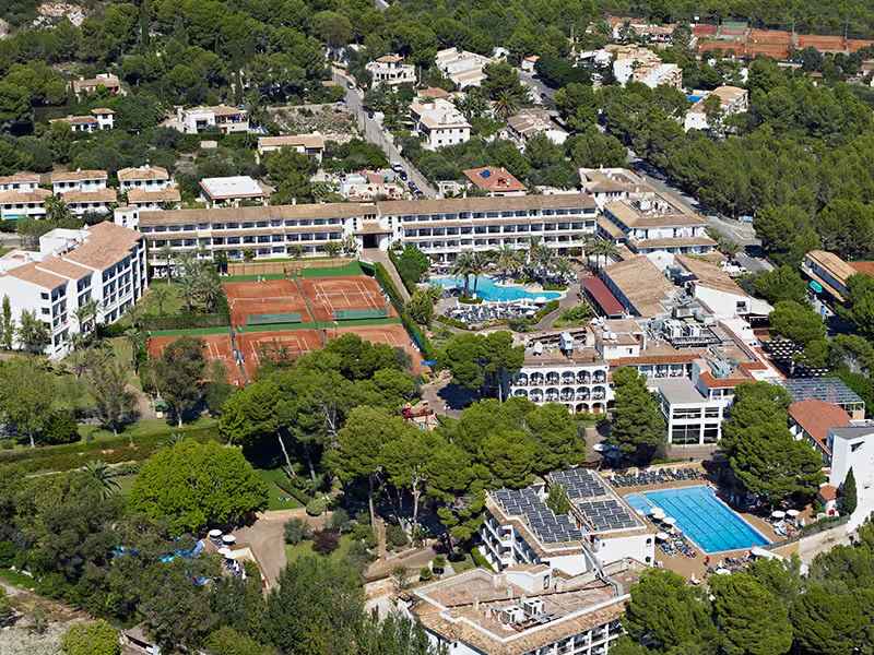 Aerial view of Beach Club School Tours hotel, highlighting tennis courts, swimming pools, and surrounding greenery.