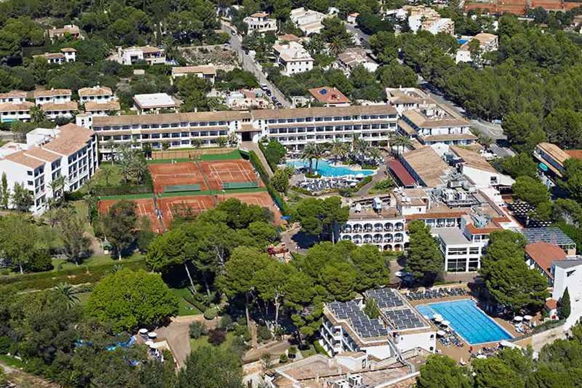 Aerial view of Beach Club School Tours hotel, highlighting tennis courts, swimming pools, and surrounding greenery.