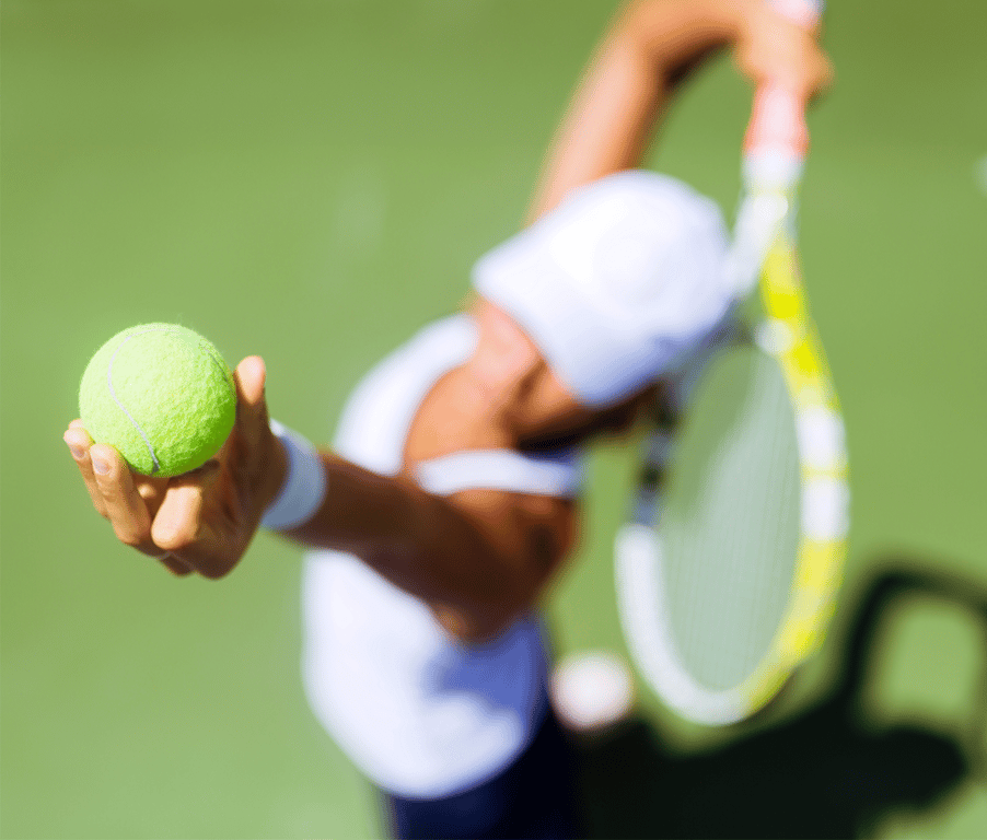 Tennis player serving a ball on a court