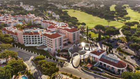 Aerial view of Hilton Vilamoura Hotel in Portugal with surrounding greenery and golf course.