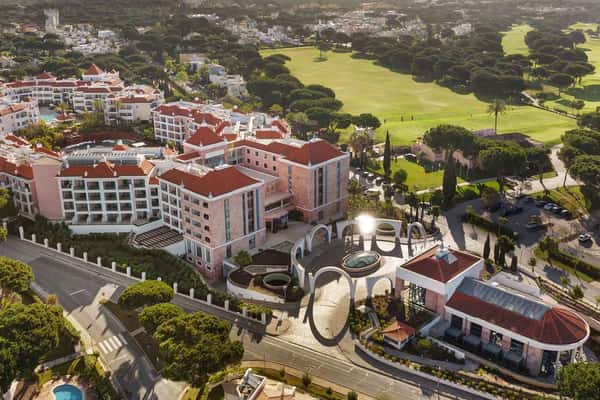 Aerial view of Hilton Vilamoura Hotel in Portugal with surrounding greenery and golf course.