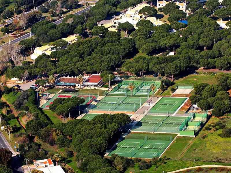 Aerial view of Prado Vilamoura tennis courts surrounded by greenery and facilities.