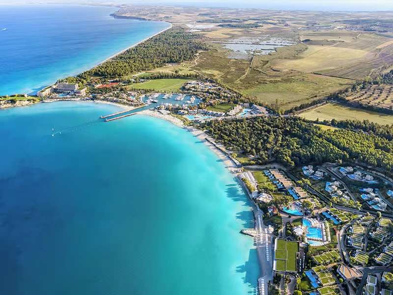 Aerial view of Sani Resort island, featuring turquoise waters, pristine beaches, and lush surroundings.