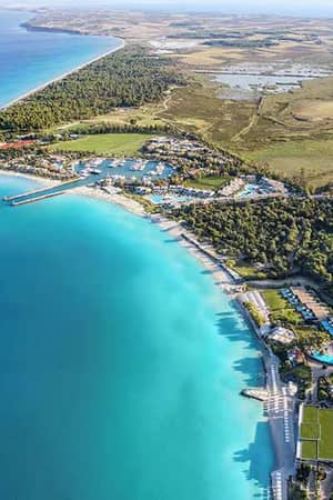 Aerial view of Sani Resort island, featuring turquoise waters, pristine beaches, and lush surroundings.