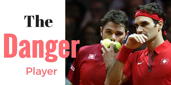 Roger Federer and Stan Wawrinka in red shirts on tennis court holding tennis balls.