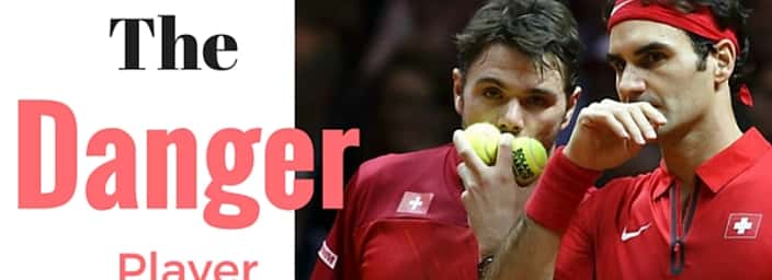 Roger Federer and Stan Wawrinka in red shirts on tennis court holding tennis balls.
