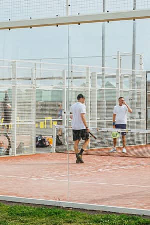 A group playing padel on the outdoor courts at Hove Beach Park in Brighton.