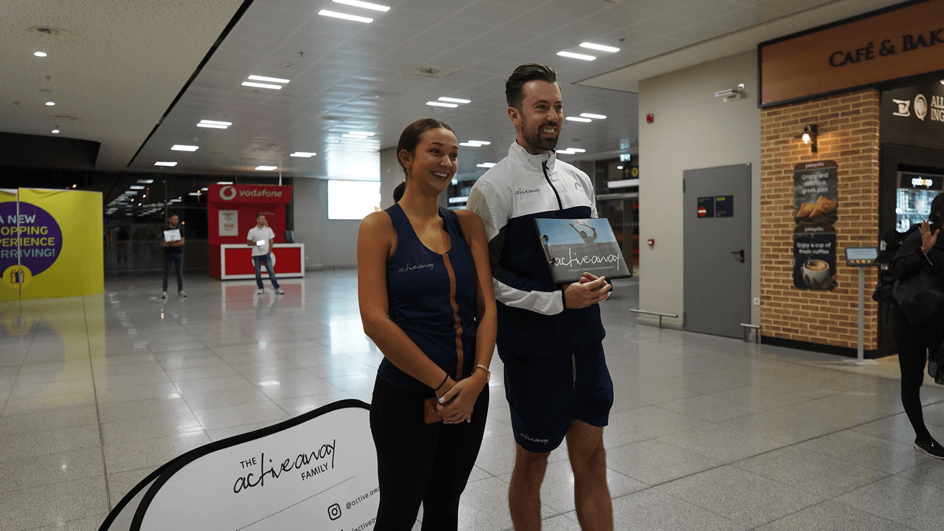 Active Away staff smiling in an airport, ready to meet guests for transfers.
